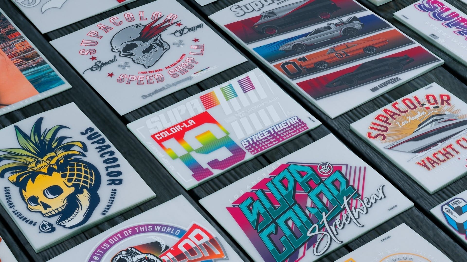 Collection of Supacolor heat transfer designs and color samples displayed on white backing cards